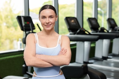 Photo of Portrait of professional personal trainer in sport center. Space for text