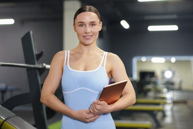 Photo of Professional personal trainer with tablet in gym