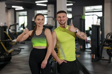 Photo of Personal trainers showing thumbs ups in gym