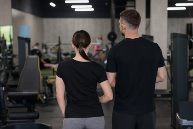 Photo of Personal trainers in sport center, back view