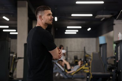 Photo of Professional personal trainer in sport center. Space for text