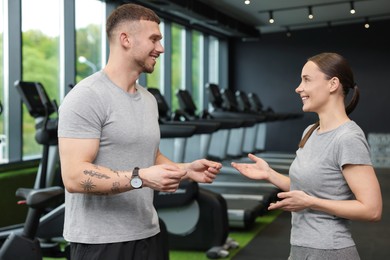Photo of Professional personal trainers talking in sport center