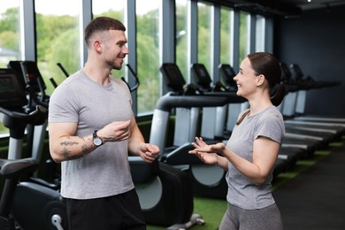 Photo of Professional personal trainers talking in sport center