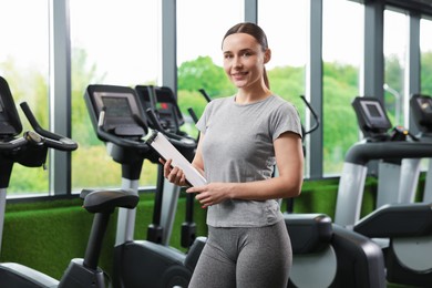Photo of Professional personal trainer with clipboard in gym