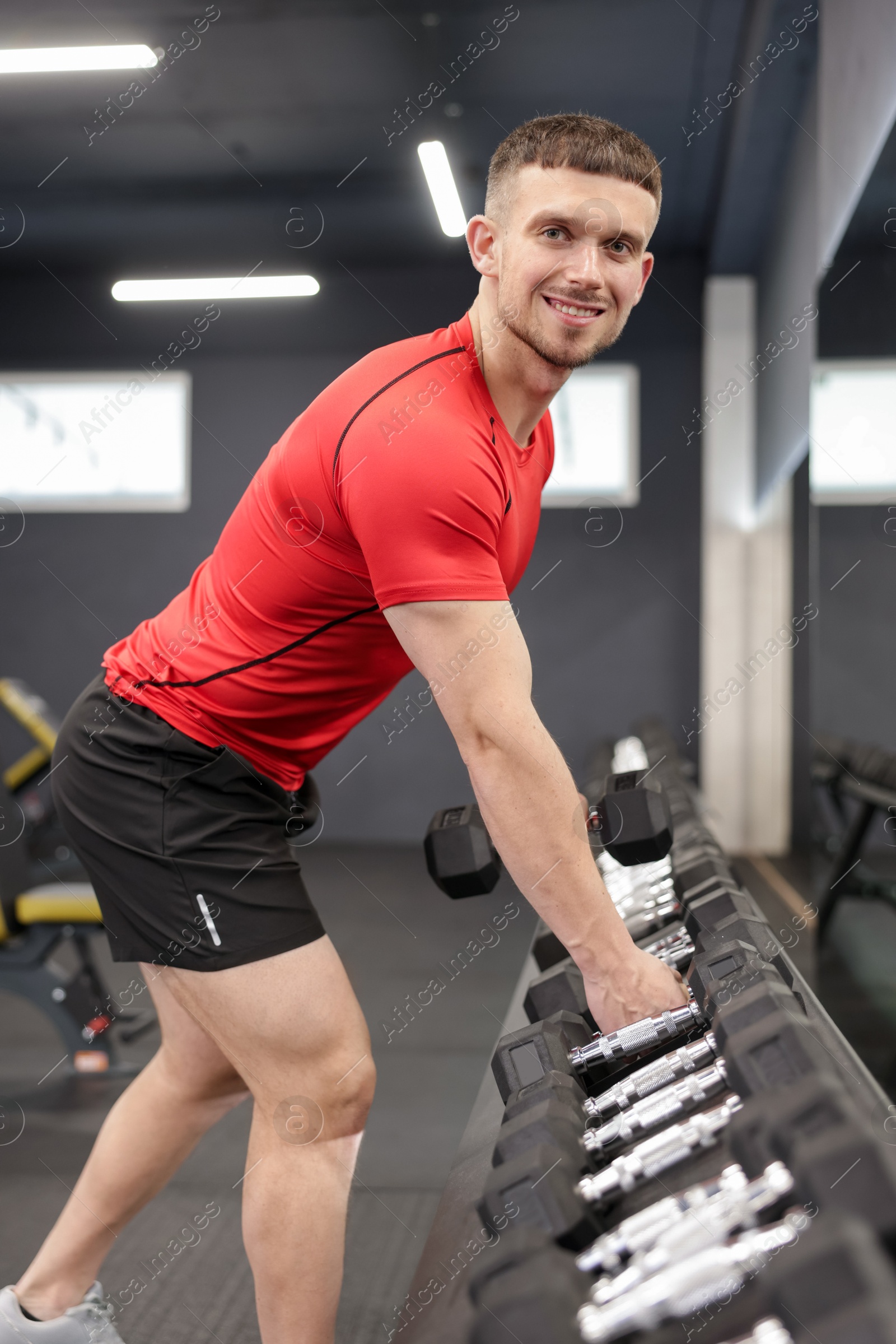 Professional personal trainer with dumbbells in gym Photo of Professional personal trainer with dumbbells in gym