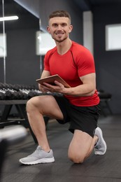 Photo of Personal trainer with tablet in sport center