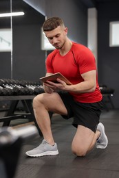 Photo of Personal trainer with tablet in sport center