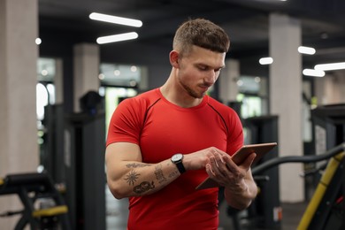 Photo of Personal trainer with tablet in sport center