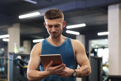 Photo of Personal trainer with tablet in sport center