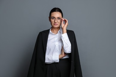 Photo of Confident business woman in suit on grey background