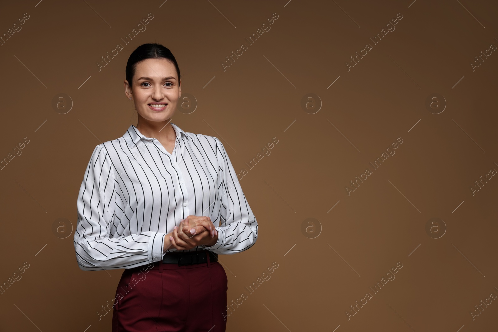 Portrait of confident business woman on brown background. Space for text Photo of Portrait of confident business woman on brown background. Space for text