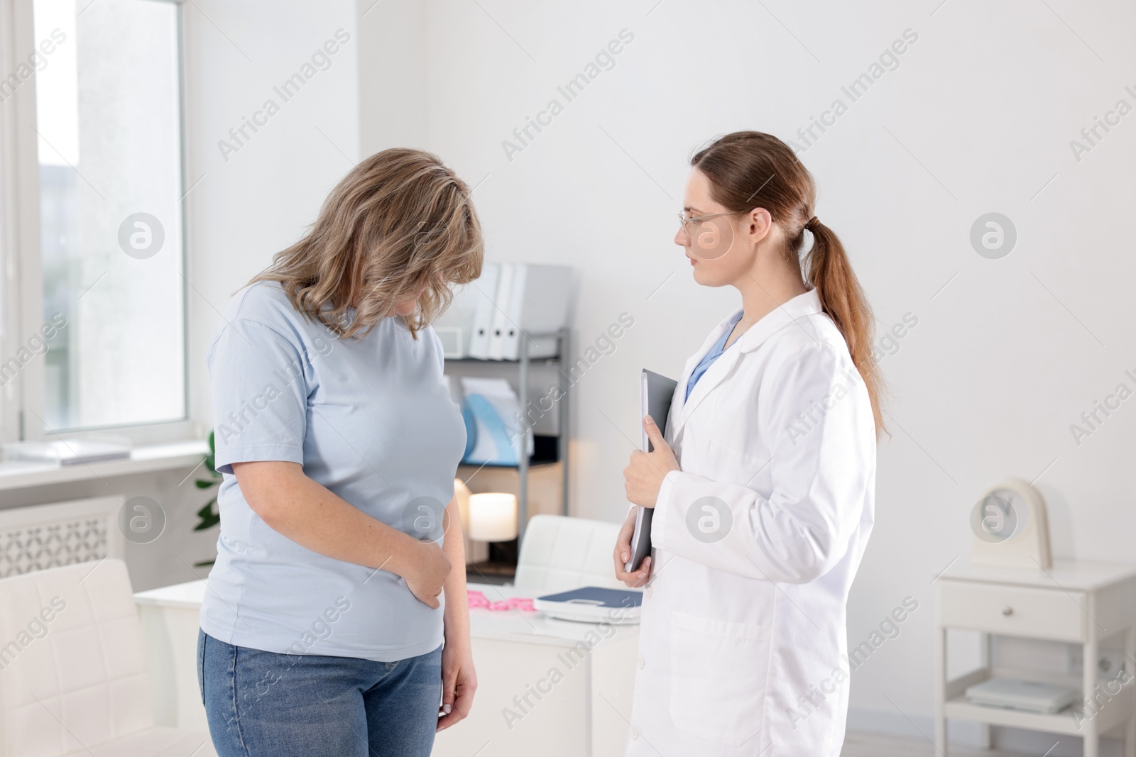 Photo of Weight loss. Nutritionist consulting overweight woman in clinic
