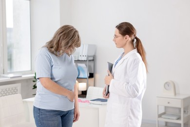 Photo of Weight loss. Nutritionist consulting overweight woman in clinic
