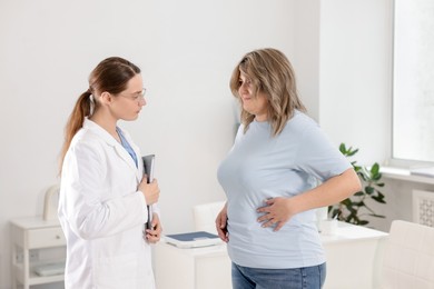 Photo of Weight loss. Nutritionist consulting overweight woman in clinic