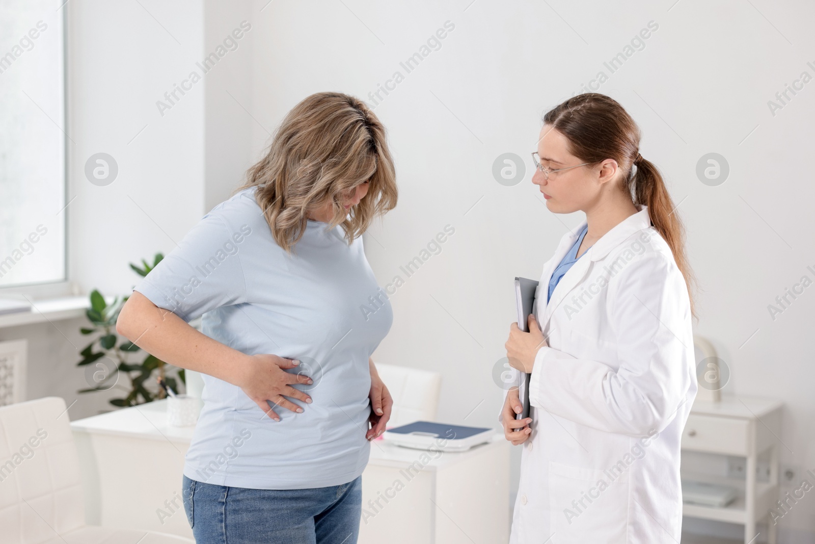 Photo of Weight loss. Nutritionist consulting overweight woman in clinic