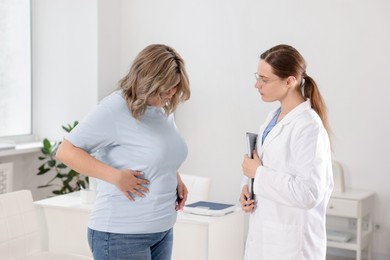 Photo of Weight loss. Nutritionist consulting overweight woman in clinic