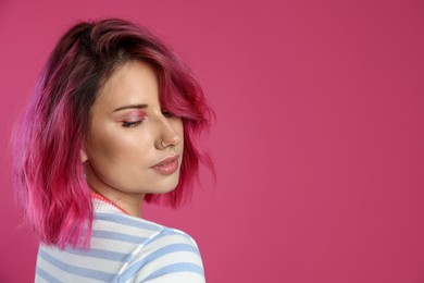 Photo of Beautiful woman with bright dyed hair on pink background, space for text