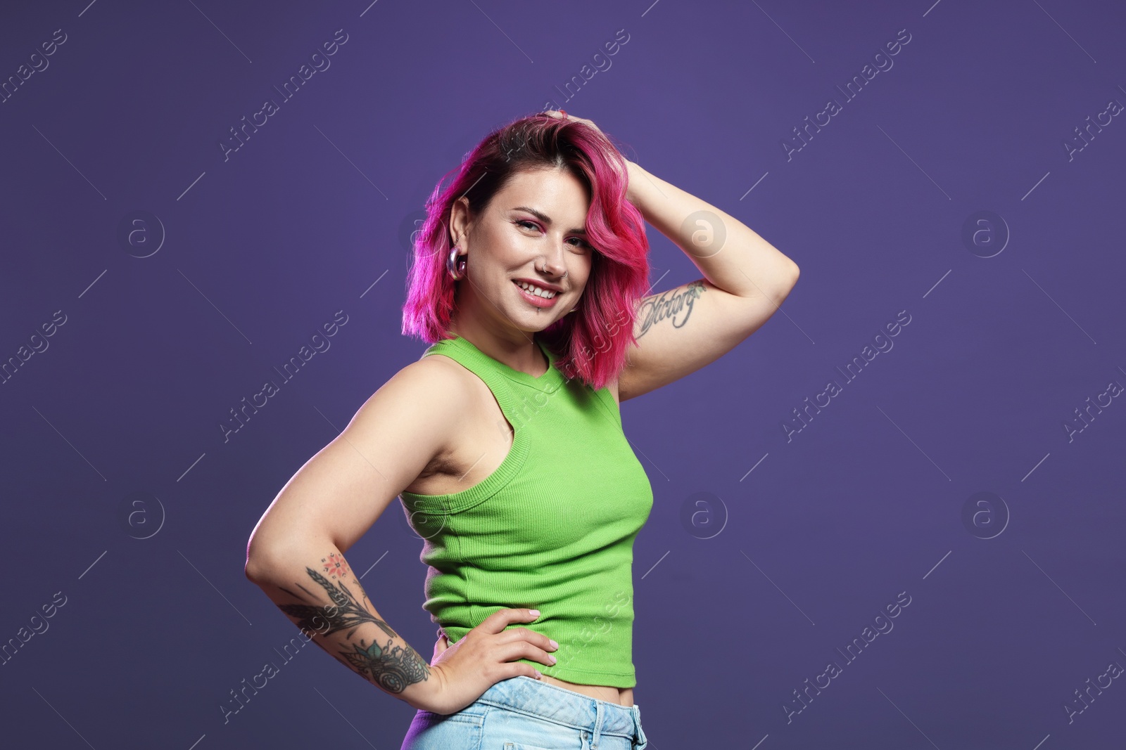 Photo of Beautiful woman with pink dyed hair on violet background