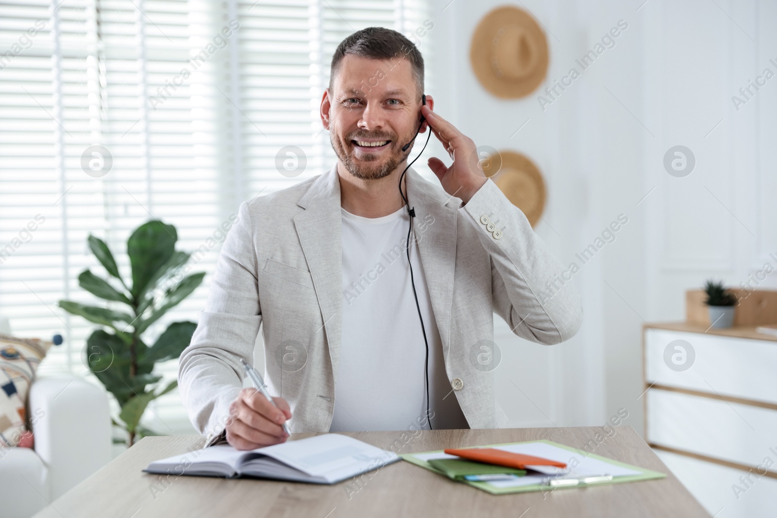 Travel agent working at wooden table in office Photo of Travel agent working at wooden table in office
