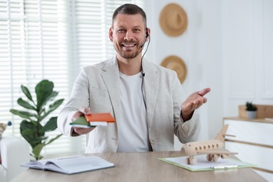 Photo of Travel agent with passports and tickets at wooden table in office