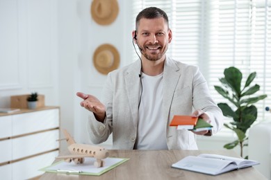 Photo of Travel agent with passports and tickets at wooden table in office