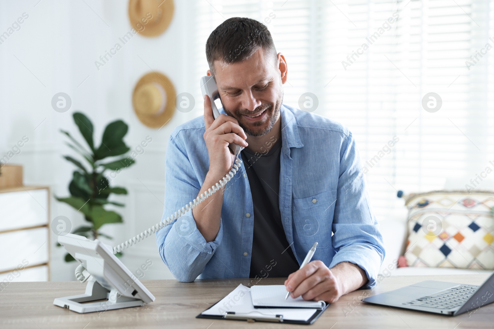 Travel agent working at wooden table in office Photo of Travel agent working at wooden table in office