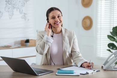 Photo of Travel agent working at wooden table in office