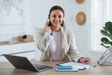 Photo of Travel agent working at wooden table in office
