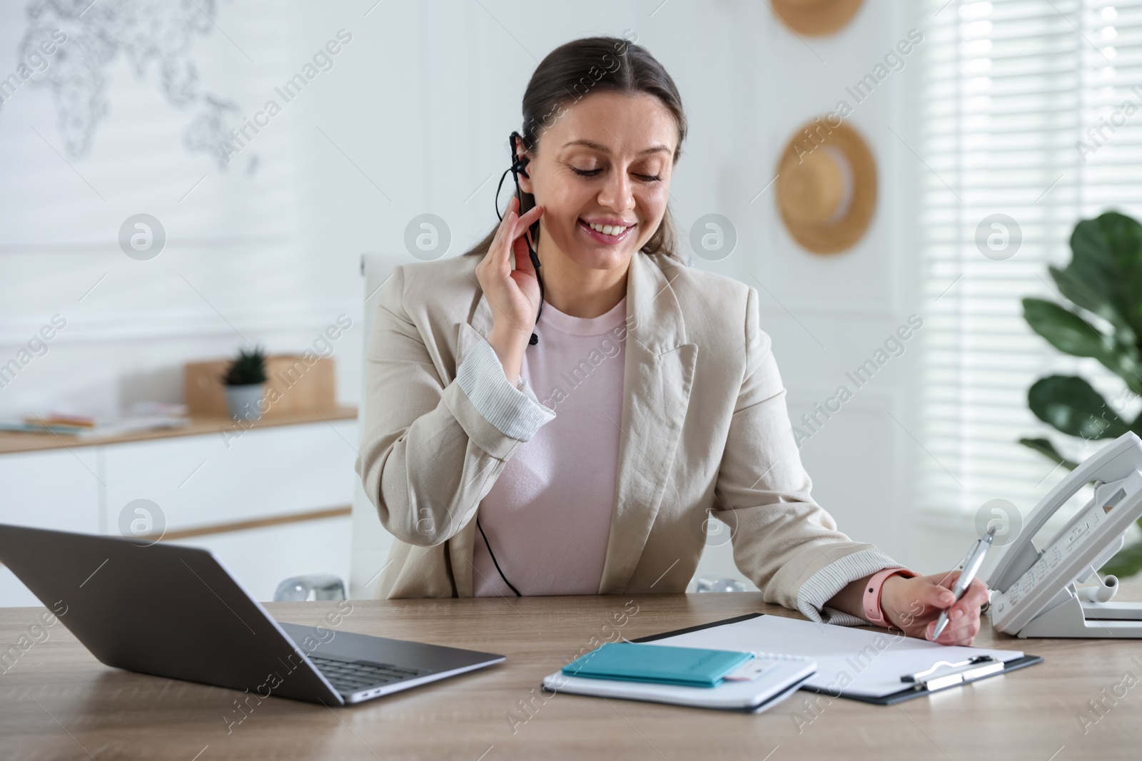 Travel agent working at wooden table in office Photo of Travel agent working at wooden table in office