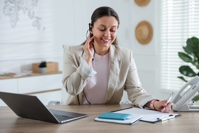 Photo of Travel agent working at wooden table in office