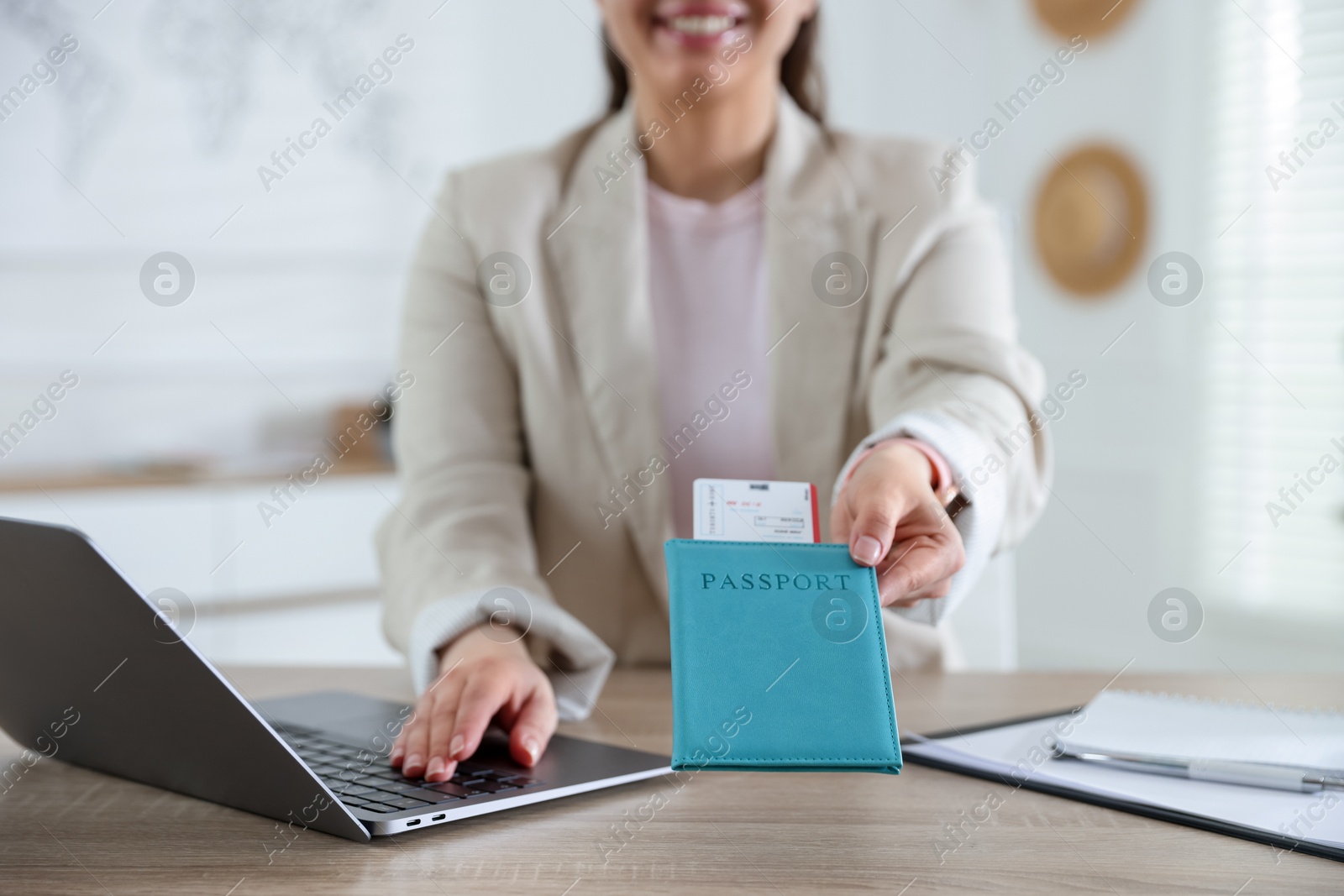 Travel agent with passport and ticket at wooden table in office, closeup Photo of Travel agent with passport and ticket at wooden table in office, closeup