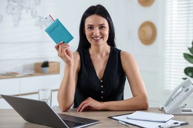 Photo of Travel agent with passport and ticket at wooden table in office
