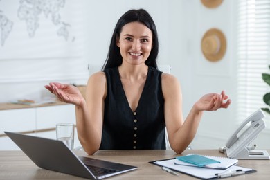 Photo of Travel agent working at wooden table in office
