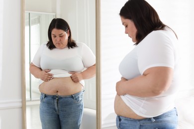 Photo of Woman with excessive belly fat near mirror indoors. Overweight problem