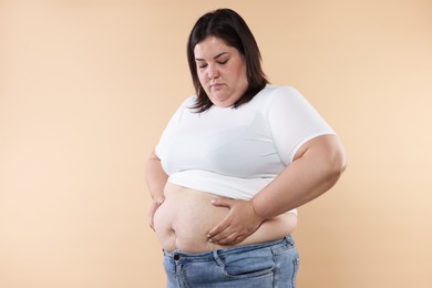 Photo of Woman with excessive belly fat on beige background