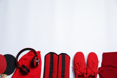 Photo of Sportswear and different gym accessories on white background, flat lay. Space for text