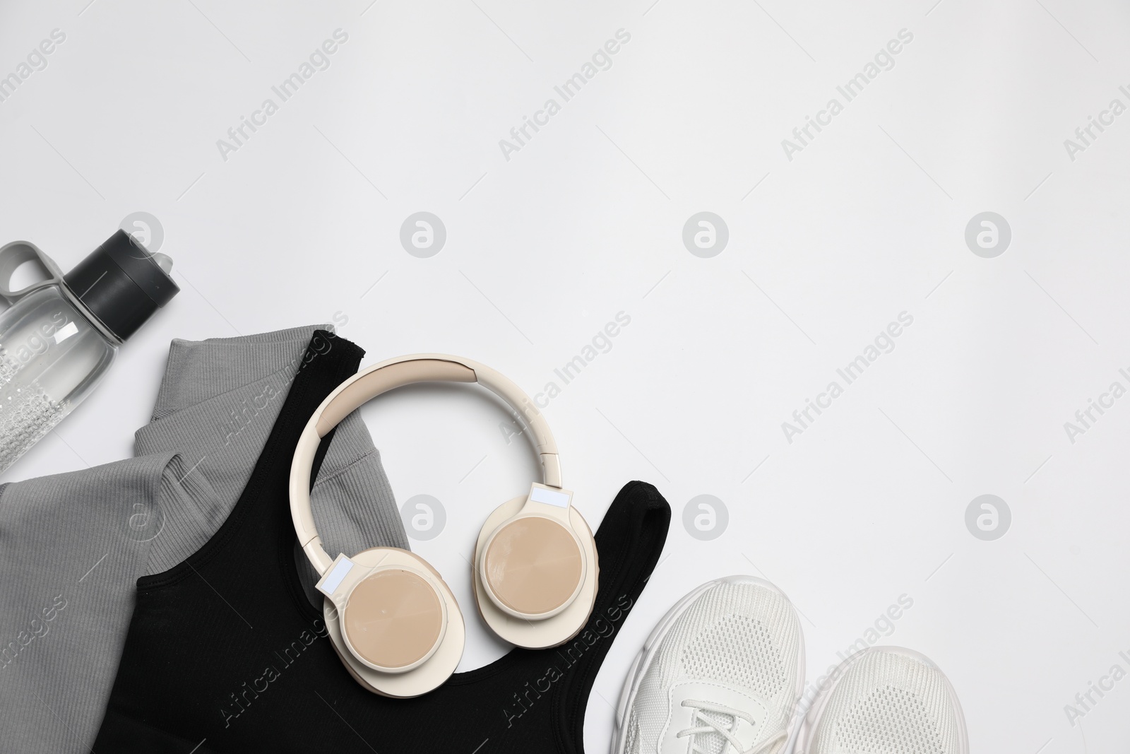 Sportswear, bottle of water, sneakers and headphones on white background, flat lay. Space for text Photo of Sportswear, bottle of water, sneakers and headphones on white background, flat lay. Space for text