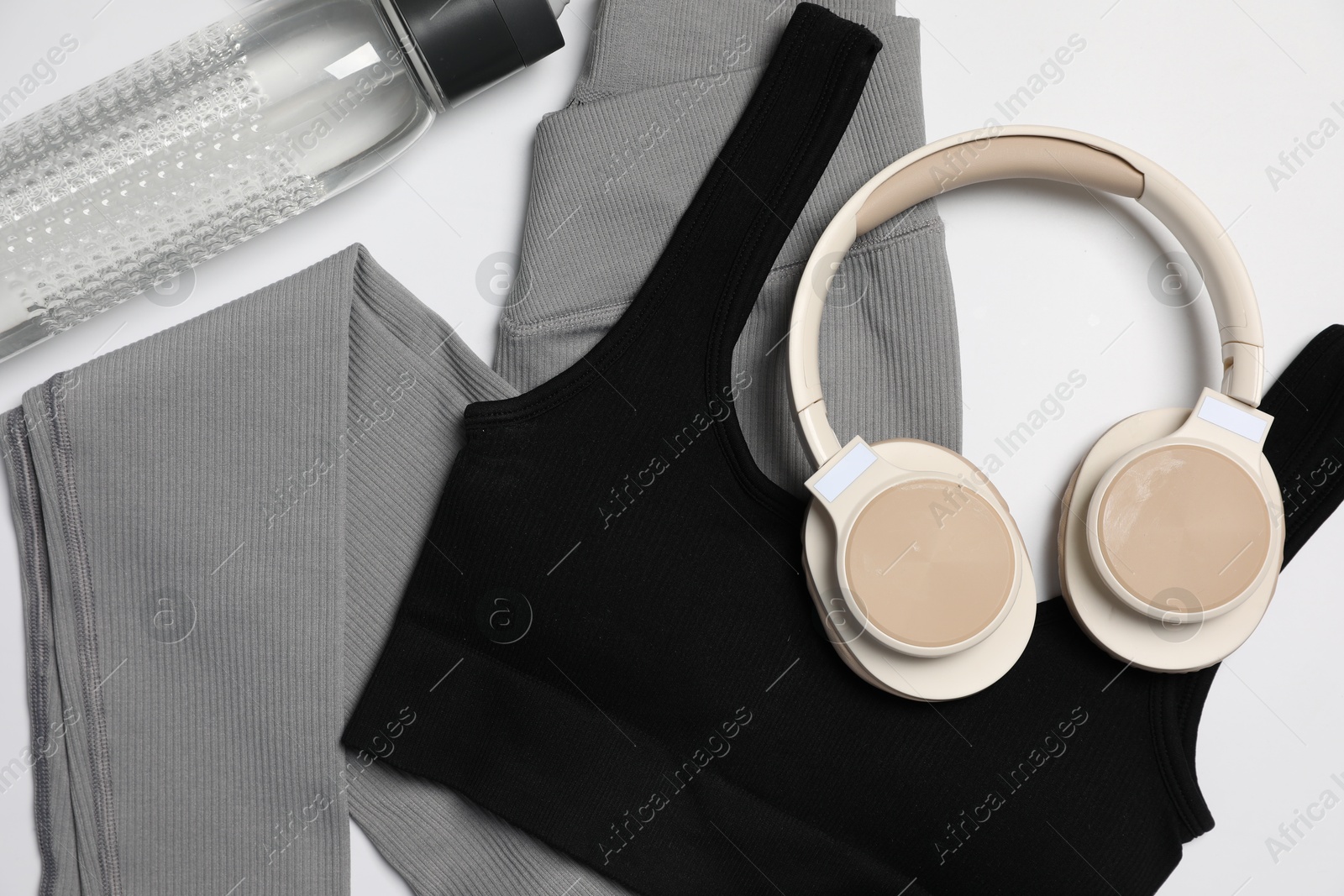 Sportswear, bottle of water and headphones on white background, flat lay Photo of Sportswear, bottle of water and headphones on white background, flat lay