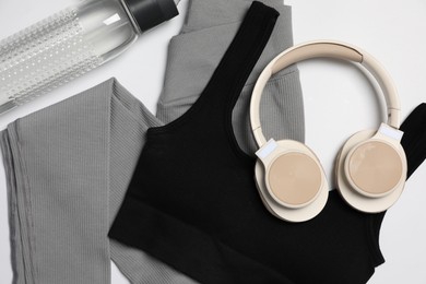 Photo of Sportswear, bottle of water and headphones on white background, flat lay