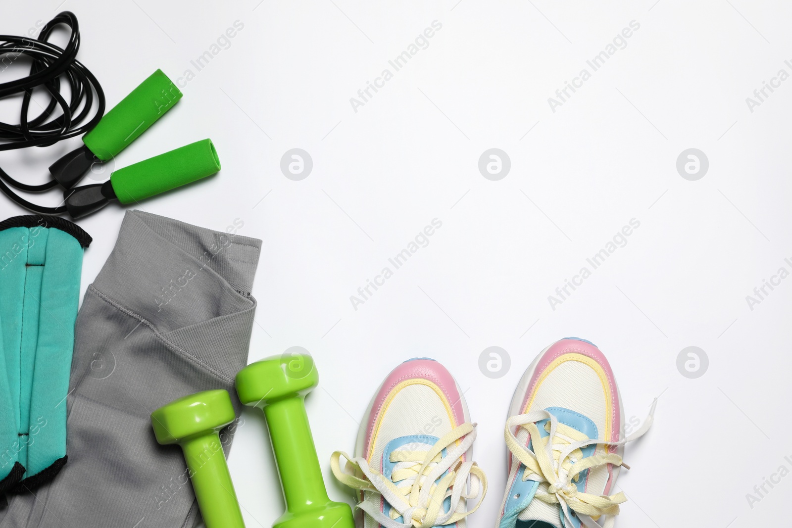 Sportswear and different gym accessories on white background, flat lay Photo of Sportswear and different gym accessories on white background, flat lay