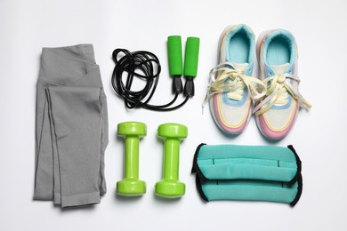 Photo of Sportswear and different gym accessories on white background, flat lay