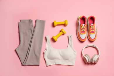 Photo of Sportswear, dumbbells, headphones and sneakers on pink background, flat lay