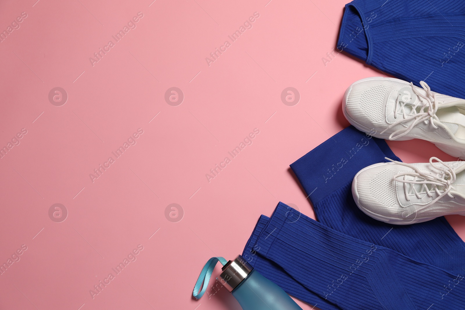 Sportswear, bottle of water and sneakers on pink background, flat lay. Space for text Photo of Sportswear, bottle of water and sneakers on pink background, flat lay. Space for text