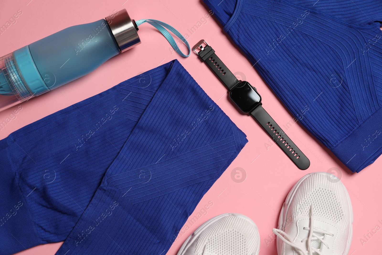 Sportswear, watch, bottle of water and sneakers on pink background, flat lay Photo of Sportswear, watch, bottle of water and sneakers on pink background, flat lay