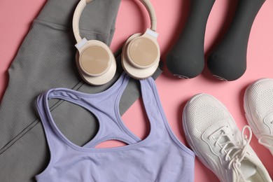Photo of Sportswear, dumbbells, headphones and sneakers on pink background, flat lay
