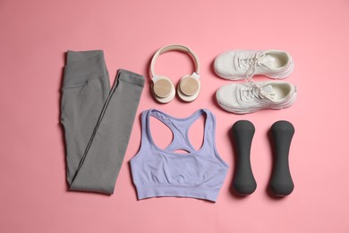 Photo of Sportswear, dumbbells, headphones and sneakers on pink background, flat lay