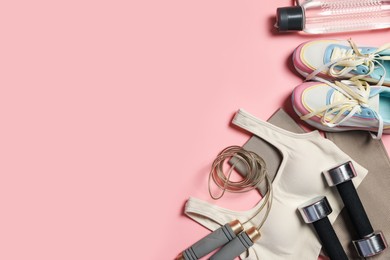 Photo of Sportswear and different gym accessories on pink background, flat lay. Space for text