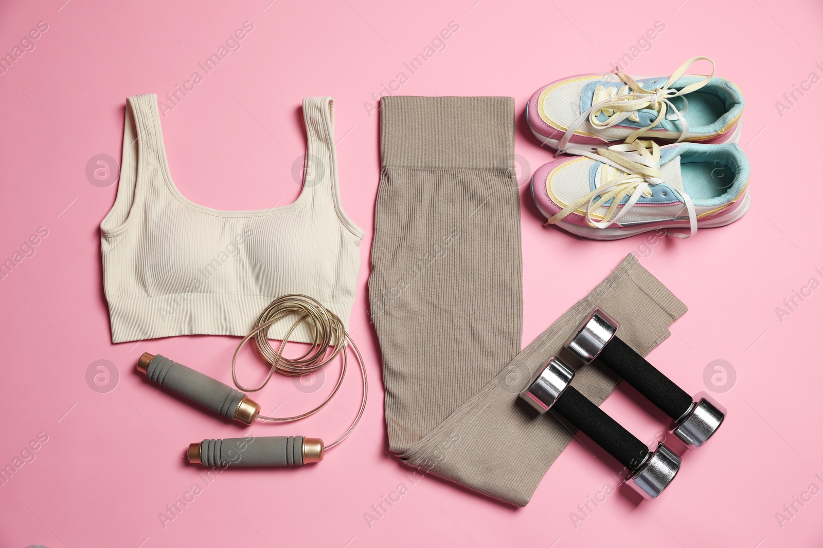 Sportswear and different gym accessories on pink background, flat lay Photo of Sportswear and different gym accessories on pink background, flat lay