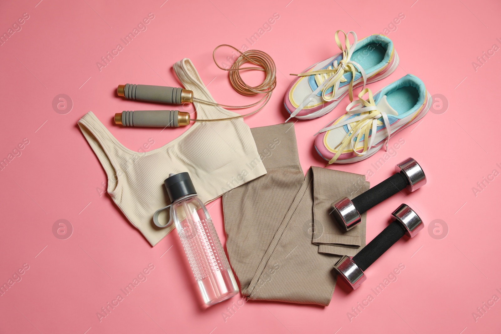 Sportswear and different gym accessories on pink background, flat lay Photo of Sportswear and different gym accessories on pink background, flat lay