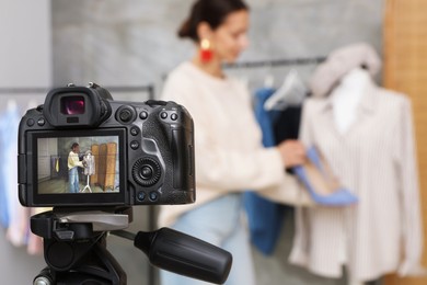 Photo of Professional stylist filming video on camera indoors, selective focus